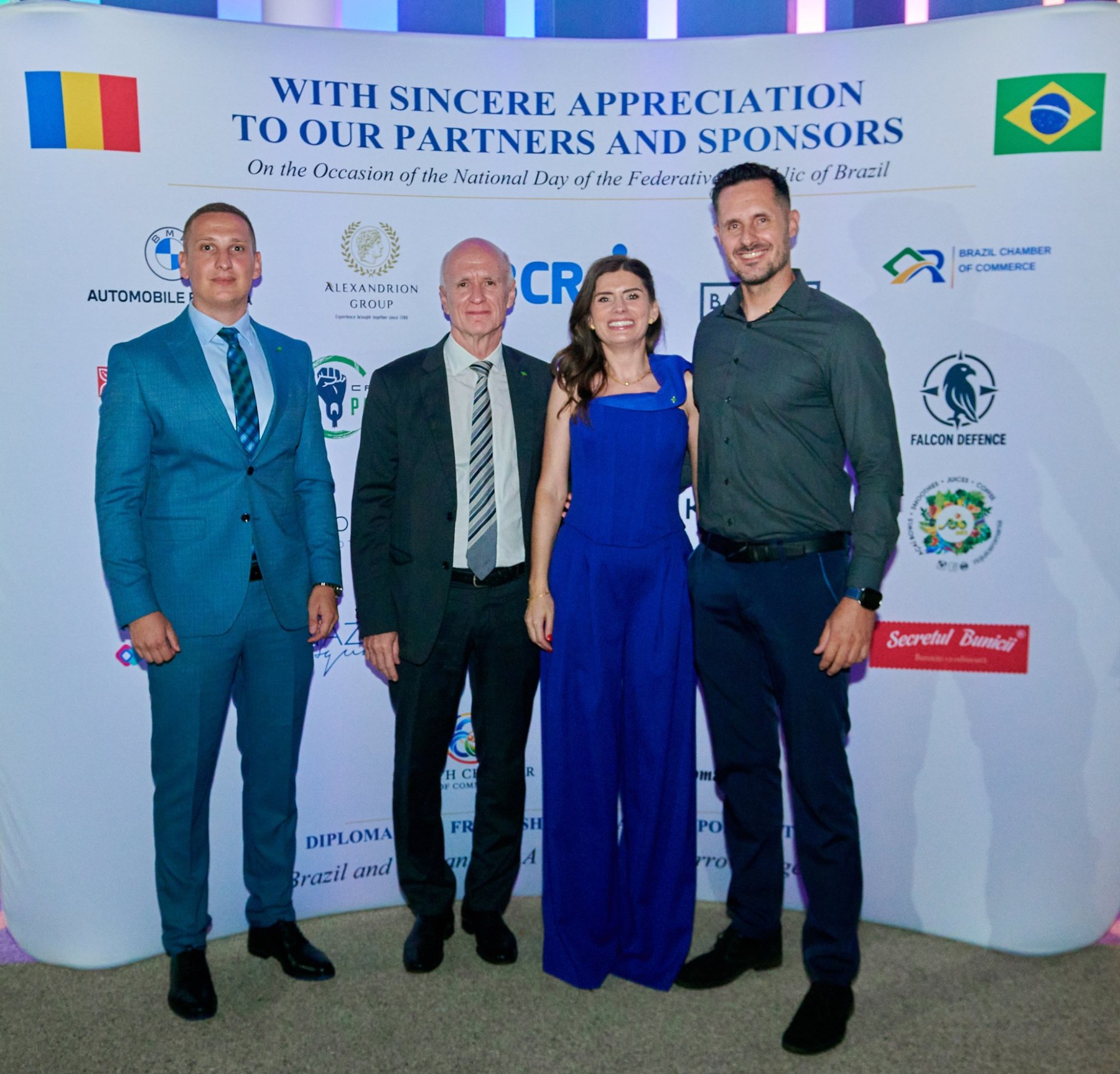 Four guests at Brazil National Day 2026 in front of a display thanking the event's partners and sponsors